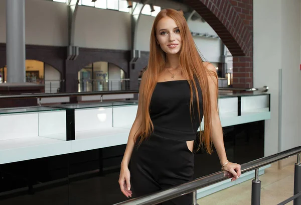 Red-haired model escort in black dress